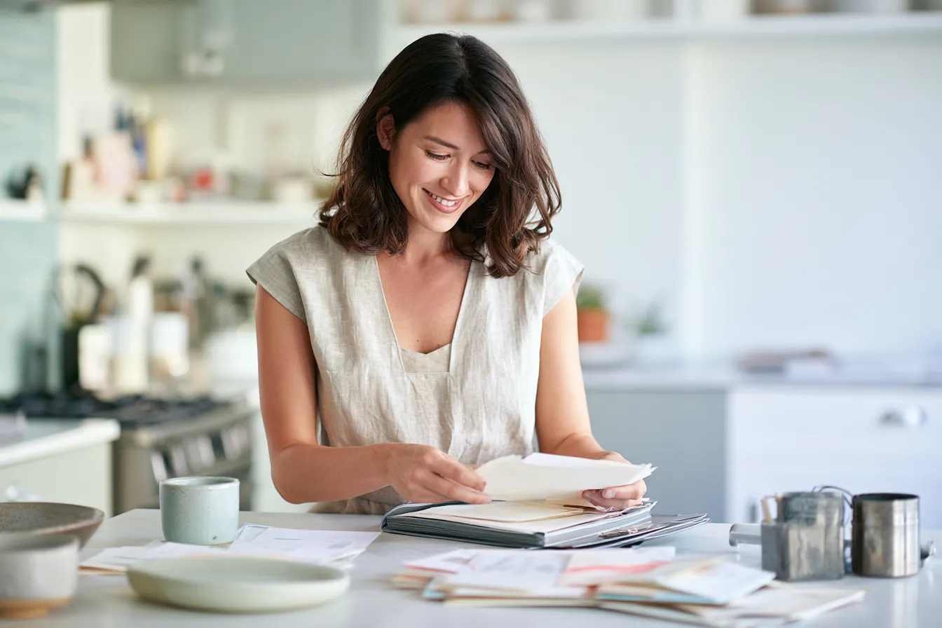 Woman consolidating paper bills into one folder before a flex loans online request